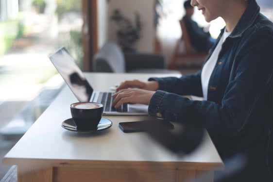 person typing on laptop with coffee - liantis case